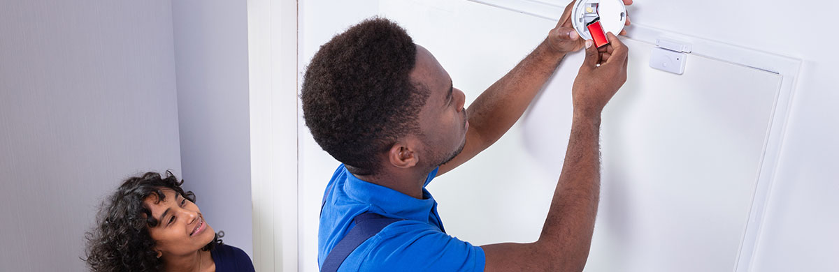 un artisan installe un DAAF dans le logement d'une femme