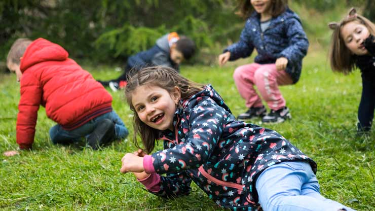 Des enfants se roulent dans l’herbe.