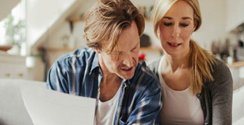 Couple consultant des documents sur le canapé
