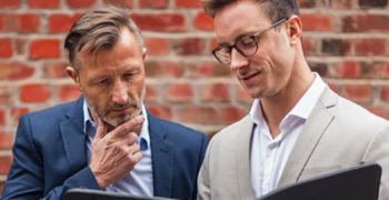 Deux hommes consultant un document dans la rue