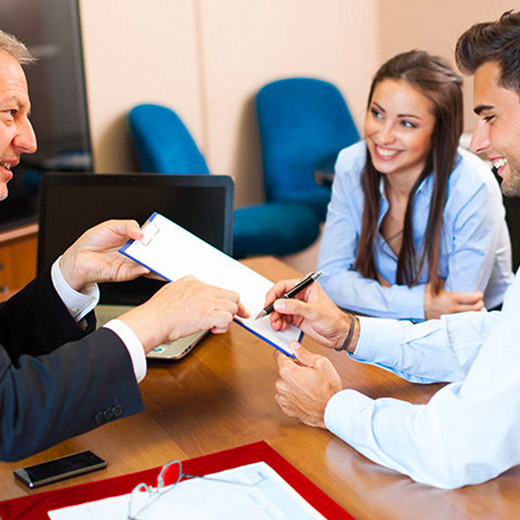 couple signant un acte de vente chez un agent